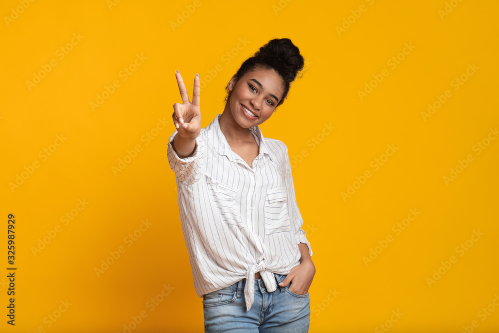 Smiling Afro Girl Showing Peace Gesture And Posing At Camera Smiling Afro Girl Showing Peace Gesture And Posing At Camera