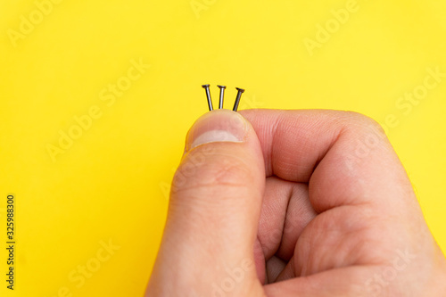 Close up of nails in mans fingers on yellow background  macro  copyspace