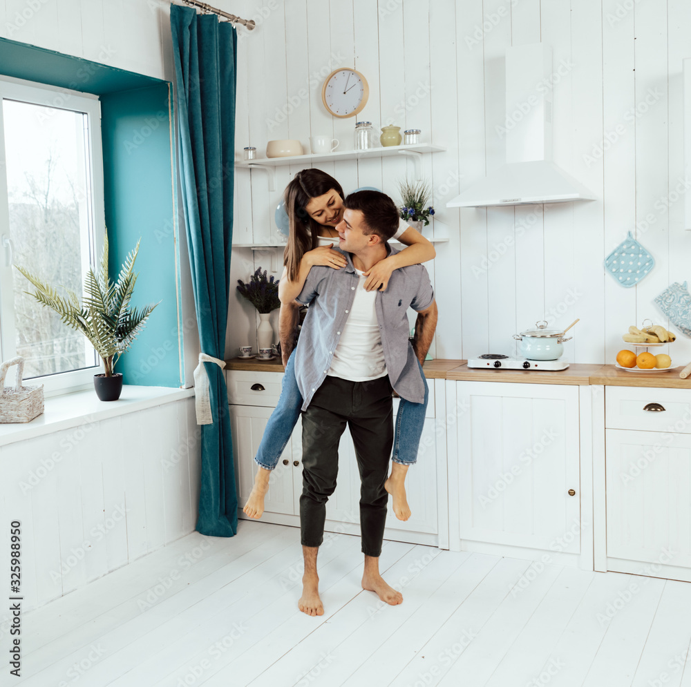 Young man and woman sitting on floor in kitchen and talking. Loving young couple spending time together at home. Young man and woman sitting on floor in kitchen and talking. Loving young couple spending time together at home.