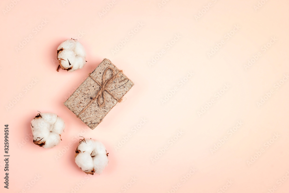 Gift with delicate сotton plant flower on pink background. Flat lay, top view with space for text. Gift with delicate сotton plant flower on pink background. Flat lay, top view with space for text.
