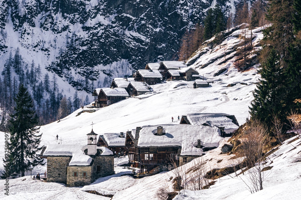 The traditional architecture of the Walser villages in the valleys of Monte Rosa, during a fantastic winter day, near the town of Alagna, Italy - February 2020.
