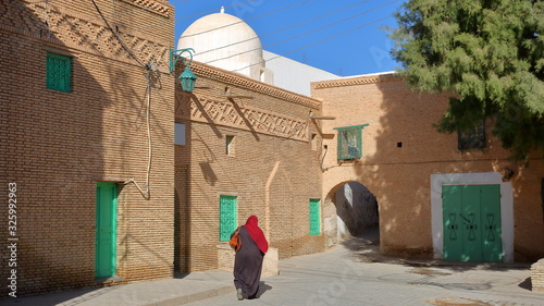 Sidi Ali Ben Sayari Square, located inside the historical brick decorated medina of Nefta, Tunisia, with a mosque and a whitewashed dome photo