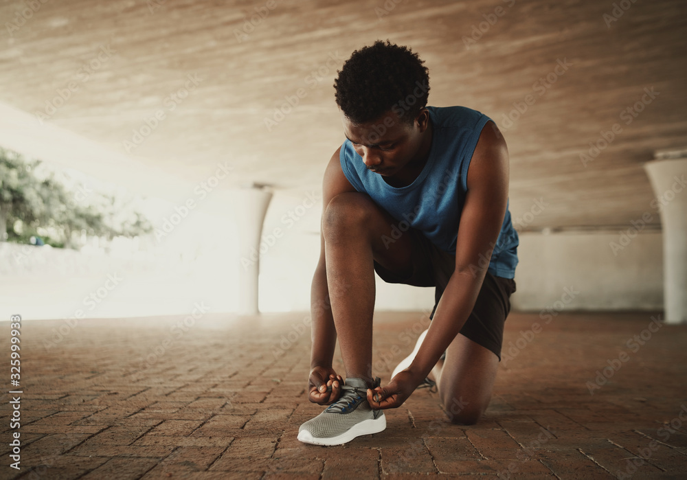 Ταπετσαρία Sportsman tying shoelace and getting ready for fitness on city street
