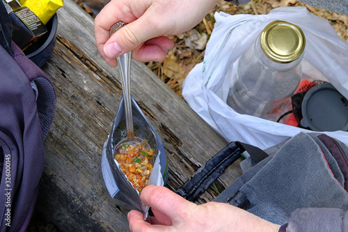 Valokuva Tourist is eating freeze dried food during resting