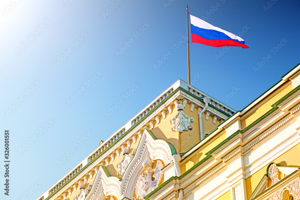 russian flag on top of kremlin palace landmark in moscow city russia against blue sky background. Closeup view of national symbol of russia. Historic russian architecture facade of kremlin building