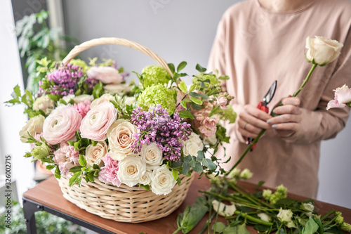 Bild auf Leinwand Woman florist creating beautiful bouquet in flower shop