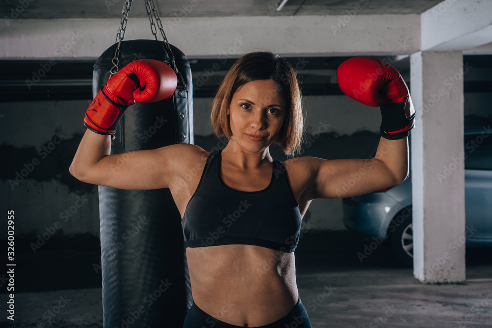 Portrait of confident young woman wearing red boxing gloves and black sports  bra Stock Photo