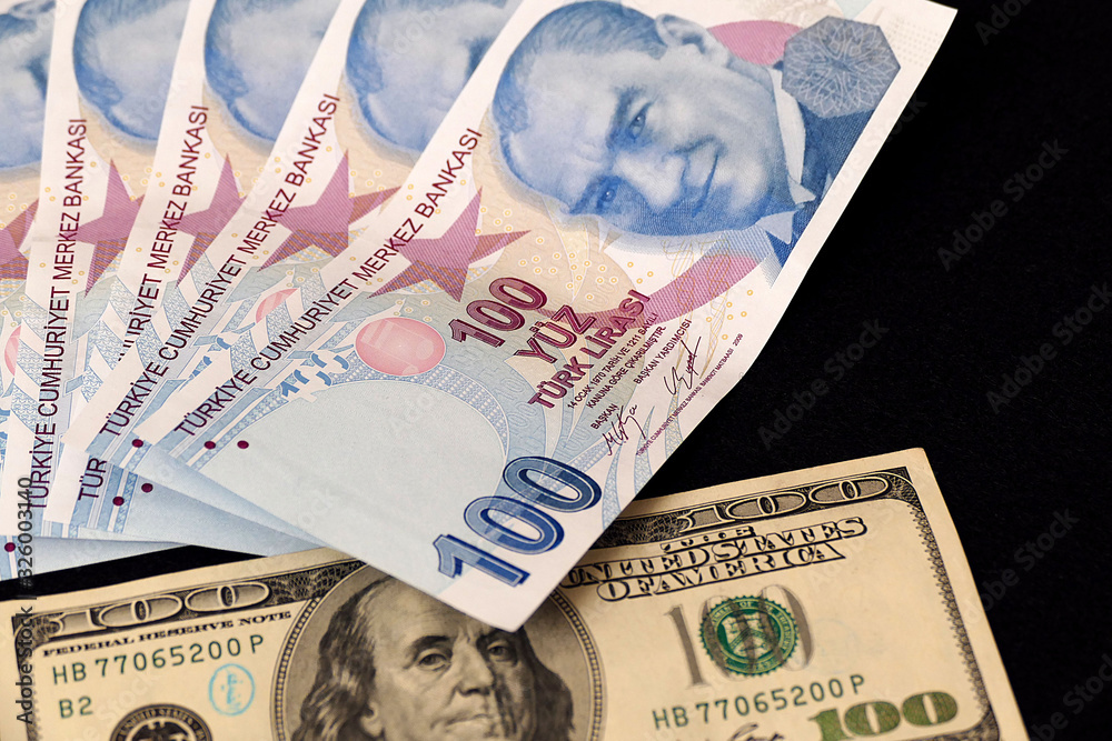 100 Turkish lira and 100 US dollars side by side, 100 Turkish lira and