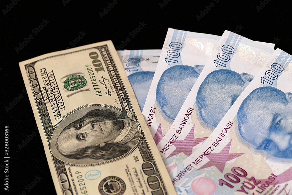 100 Turkish lira and 100 US dollars side by side, 100 Turkish lira and
