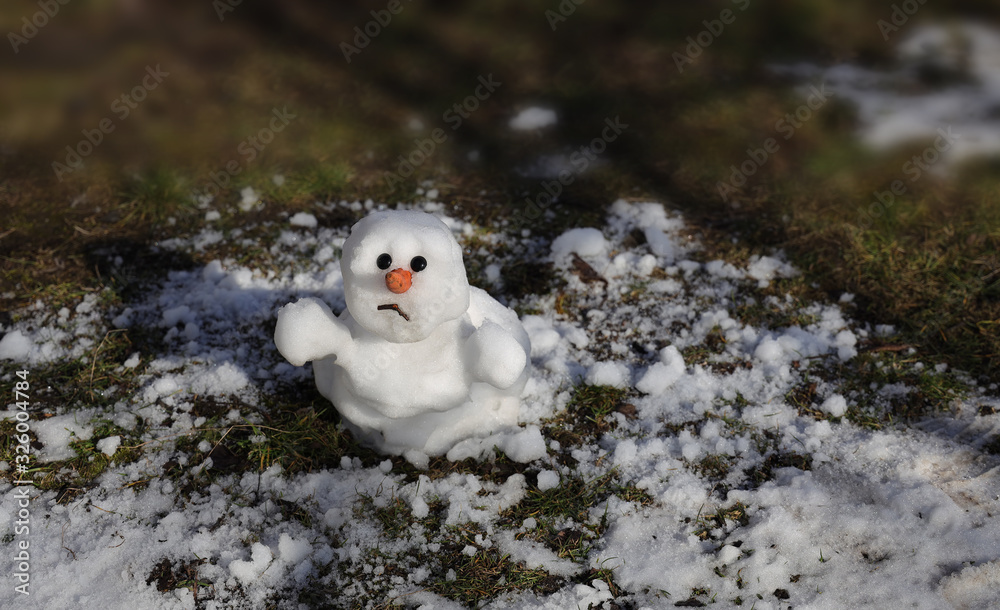 Snowman is melting in the sun. Thaw, warm winter, early spring, global warming, climate change. Spring background. Snowman is melting in the sun. Thaw, warm winter, early spring, global warming, climate change. Spring background.