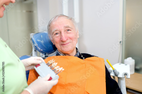 Closeup portrait of senior male 70 years old in dental office sitting in dentist chair. Dental care for older people. Dentistry, medicine and health care concept