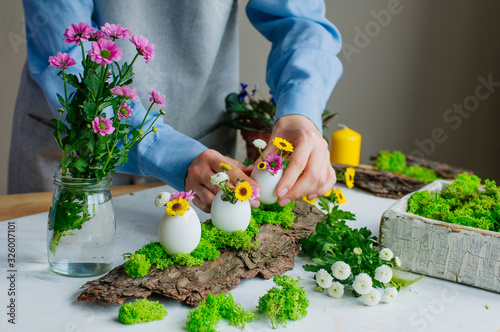 Woman preparing Easter decoration on pine bark photo