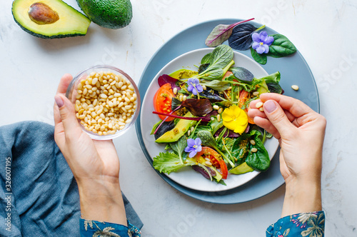 Fotografie Young woman preparing fresh healthy salad on marble background