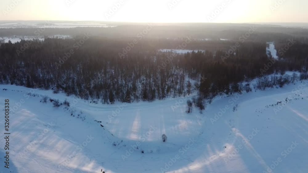 Top view of the snowy fields and forest. Quadrocopter shooting at sunset Top view of the snowy fields and forest. Quadrocopter shooting at sunset