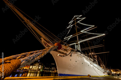 BERGEN, NORWAY - 2015  DECEMBER 23. Norwegian sailing ship Statsraad Lehmkuhl in bow with mooring rope and christmas lights photo