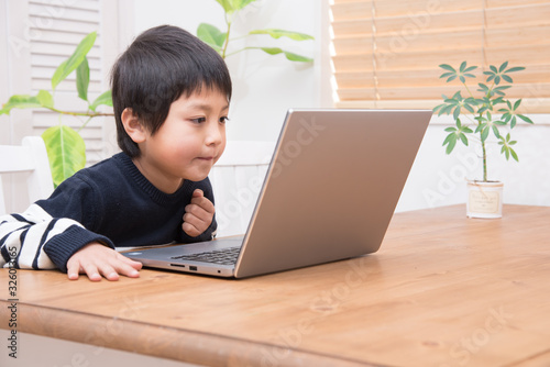 パソコンをする小学生の男の子 © tatsushi