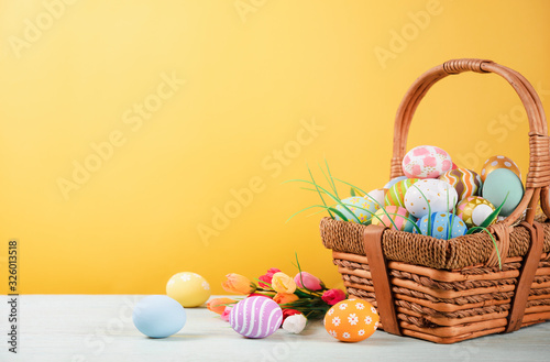 Photo Happy easter, Easter painted eggs in the basket on wooden rustic table for your decoration in holiday