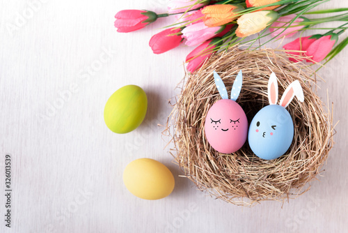 Happy easter, Easter painted eggs in nest on wooden rustic table for your decoration in holiday. Top view with copy space. photo