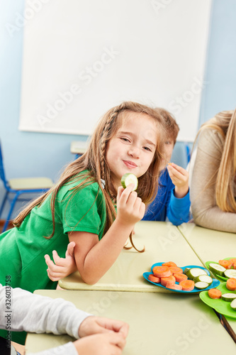 Mädchen isst frisches Gemüse als Snack photo