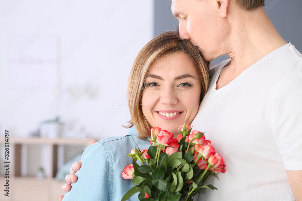 Beautiful couple with bouquet of flowers at home Beautiful couple with bouquet of flowers at home