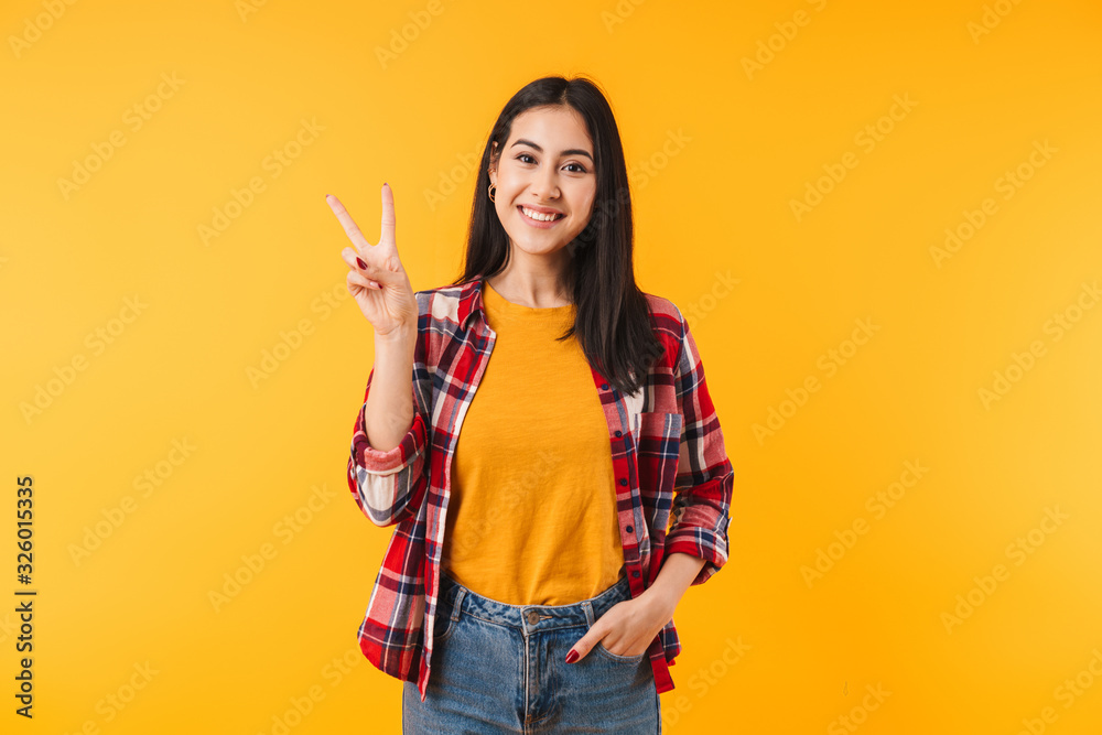 Image of joyful attractive woman smiling and showing peace sign Image of joyful attractive woman smiling and showing peace sign