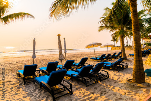 umbrella chair beach with palm tree and sea beach at sunrise times