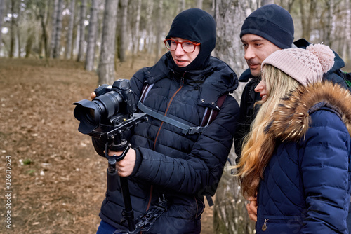 Photographer and a couple in late winter forest
