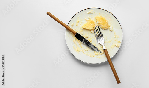 Dirty empty plate with cutlery on white background