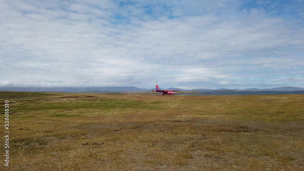 Small plane landing on the grass field on Falkland islands Small plane landing on the grass field on Falkland islands