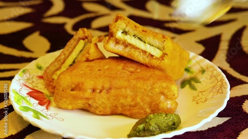 Pouring sauce on top of Paneer Pakora or Cottage Cheese Fried Snack photo