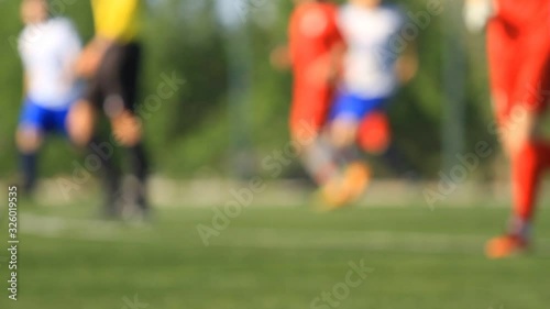 Legs of soccer players and referee in blur