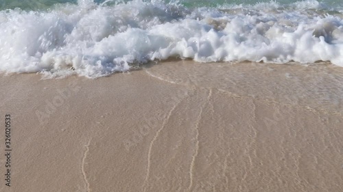 sea wave on the sand of the tropical beach close-up 60fps photo