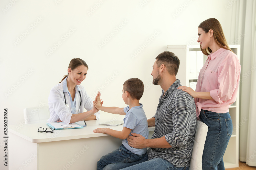 Parents and son visiting pediatrician. Doctor working with patient in hospital Parents and son visiting pediatrician. Doctor working with patient in hospital