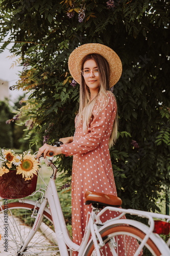 Trendy lady with bicycle in park