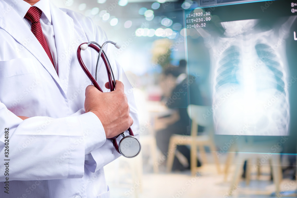 Doctor standing and holding stethoscope in hand with lung x ray film, medical concept Doctor standing and holding stethoscope in hand with lung x ray film, medical concept