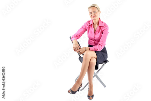 Smiling successful businesswoman sitting on a black chair on white background