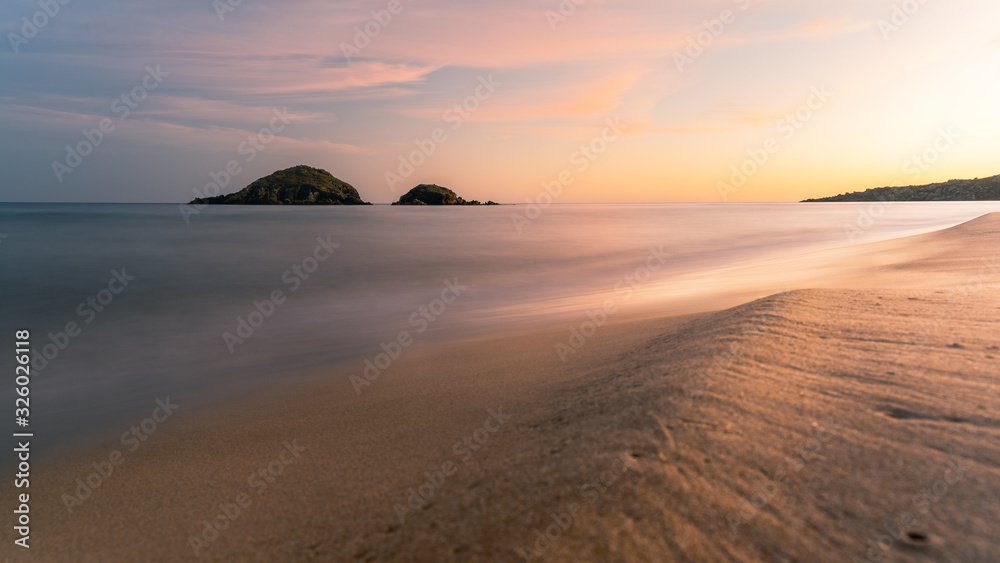 Long exposure of Su Giudeu beach at sunset, soft waves beach and sand