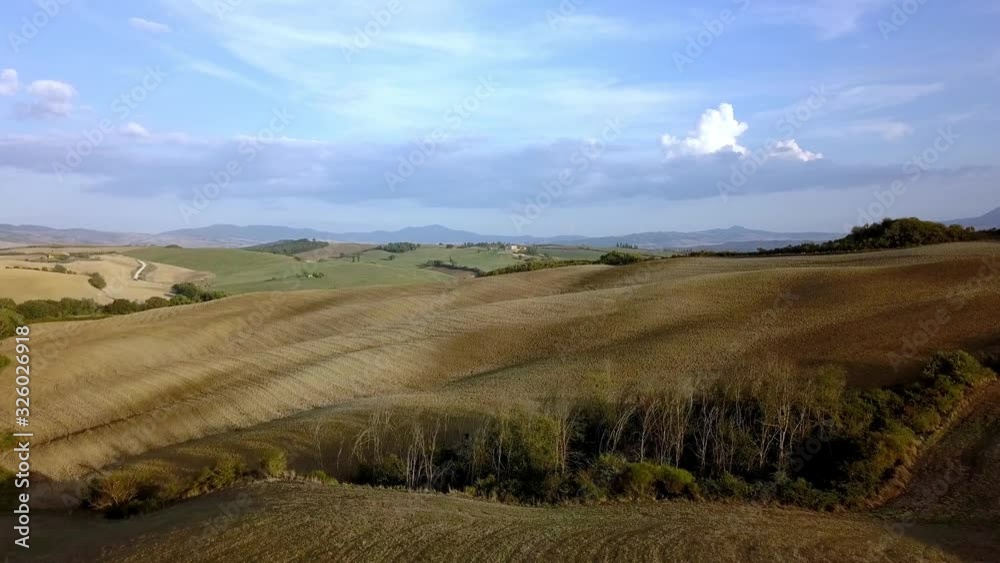 Golden fields of the Tuscan Italian countryside on a cloudy sunny day, Aerial flyover reveal shot Golden fields of the Tuscan Italian countryside on a cloudy sunny day, Aerial flyover reveal shot