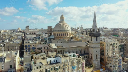 Aerial view of Valletta - capital of Malta country. Daylight, blue sky with clouds. Mediterranean sea. Camera moves from down to forward and up 