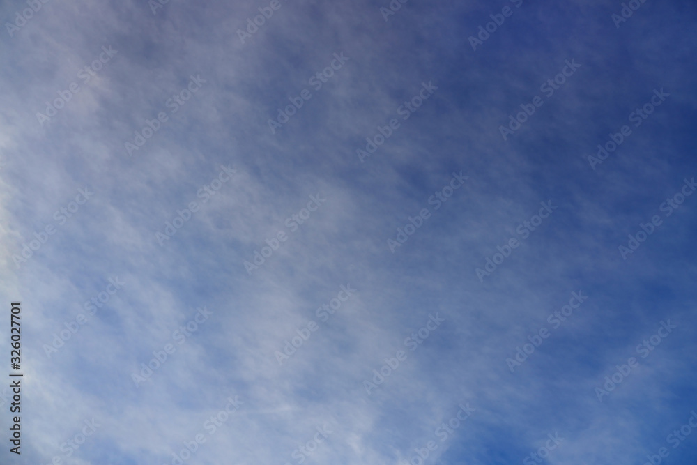 Blue sky background with light white clouds at the zenith.