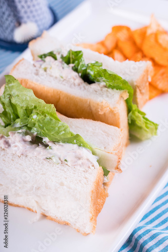 white bread with tuna spread and romaine lettuce served with cheddar potato chips