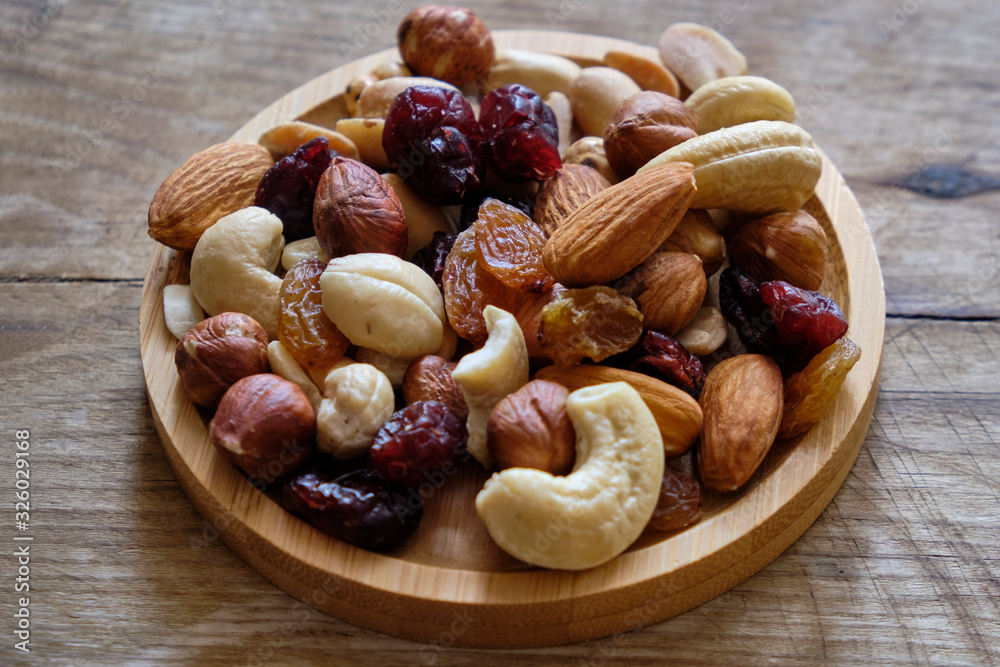 Mix of nuts and dried fruits at weathered wooden background Mix of nuts and dried fruits at weathered wooden background