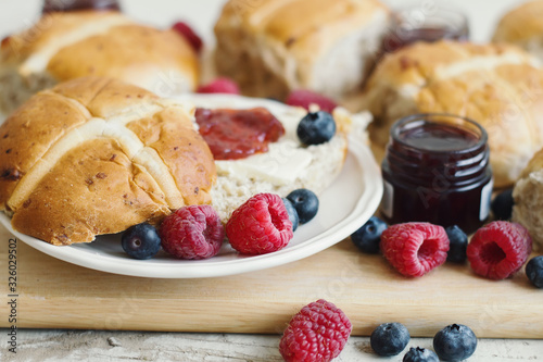 Hot cross buns with butter, jam and fresh berries. Traditional Easter breakfast