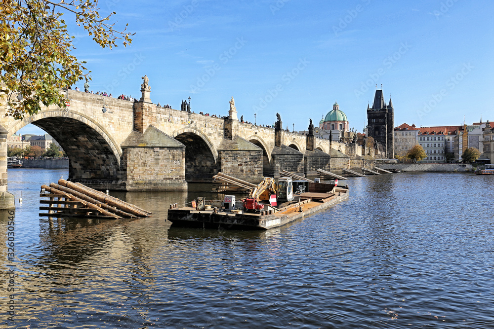 Charles bridge in Prague with construction boat on sunny day