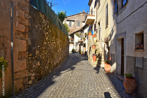 A narrow street between the old stone houses of a medieval village.