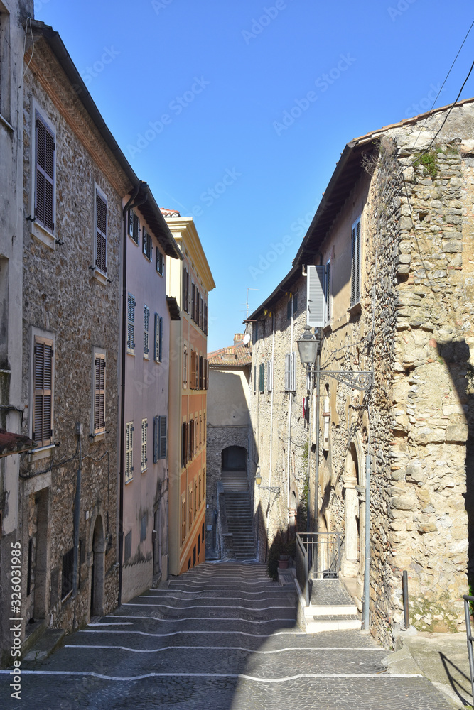 A narrow street between the old stone houses of a medieval village.
