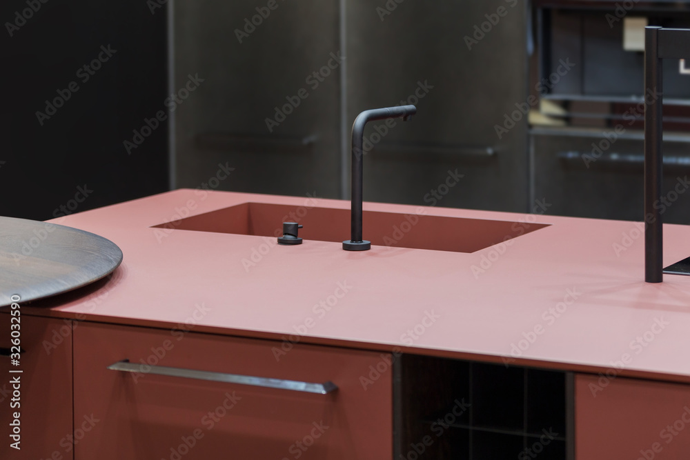 Trendy kitchen of dark red color, one-piece countertop and sink, modern designer kitchen with an island