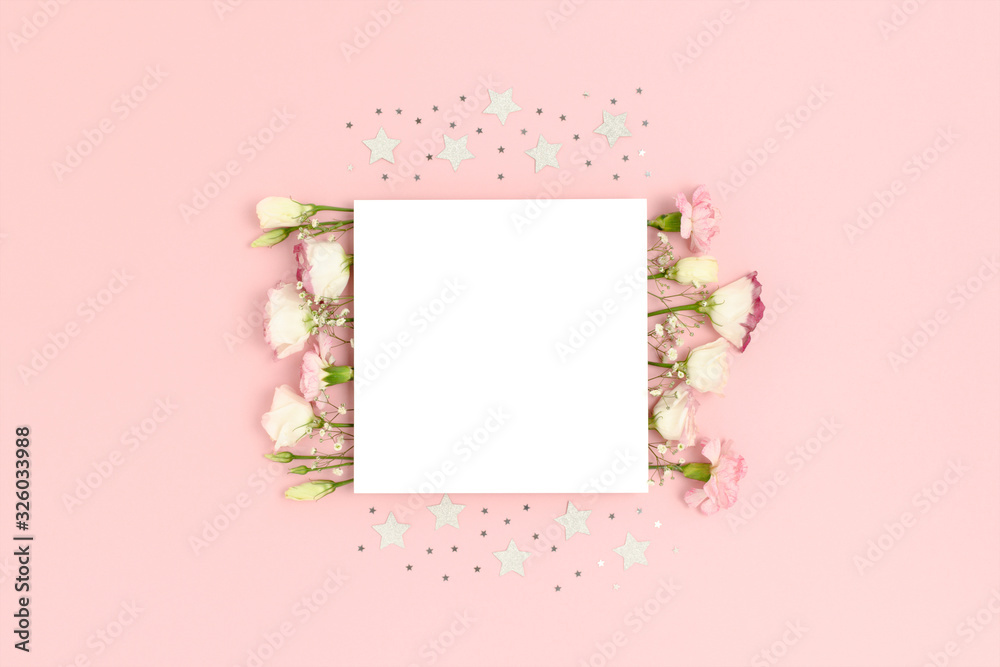 Blank paper card mockup with flowers and stars confetti. Festive concept with place for text on a pink pastel background.