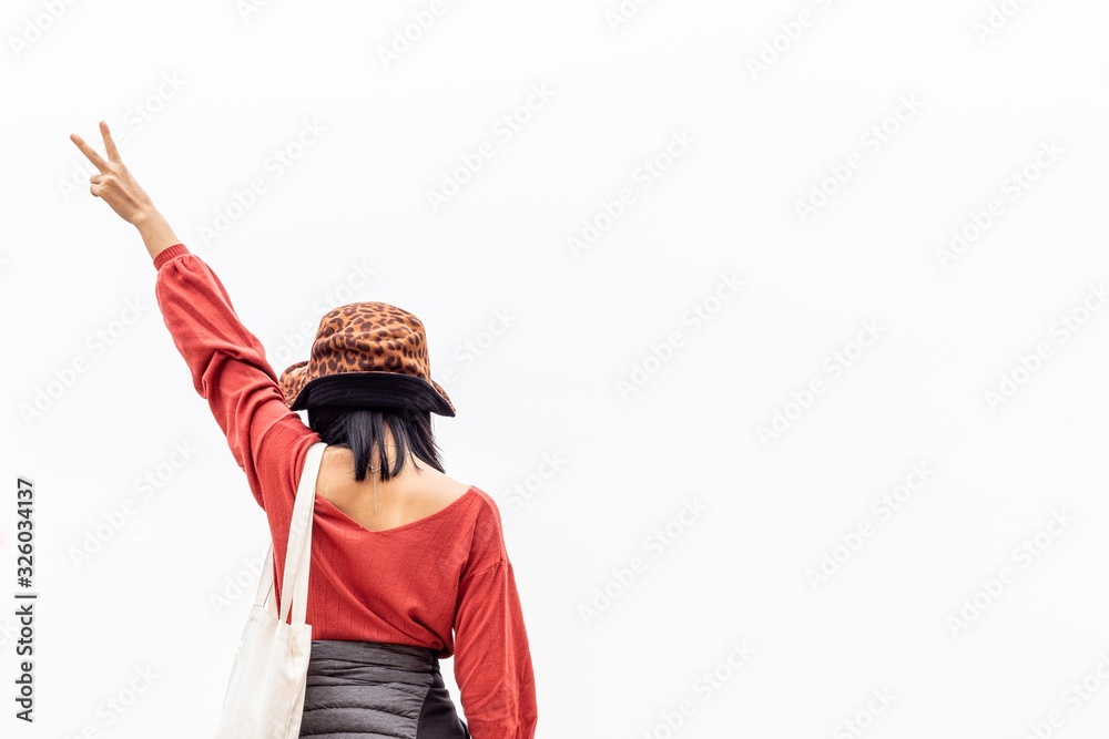 Φωτογραφία A woman holding up two fingers on the white background, A symbol of peace and victory or fighting