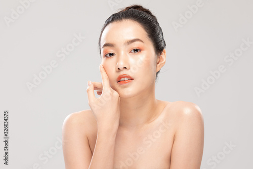 Beautiful Asian young woman touching soft cheek smile with clean and fresh skin Happiness and cheerful with positive emotional,isolated on white background,Beauty and Cosmetics Concept